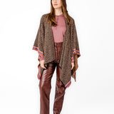 Poncho with geometric print in pink tones