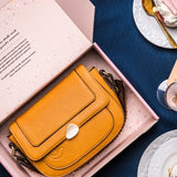 Schultertasche aus recyceltem Material in Bernsteinfarbe.