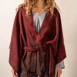 Burgundy poncho with a bow.