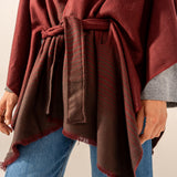 Burgundy poncho with a bow.
